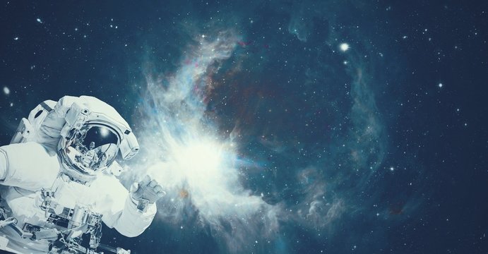 Astronaut in space suit in the outer space with the sunrise on planet and asteroids. Elements of this image furnished by NASA