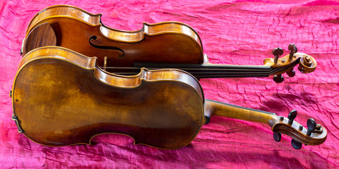 Two violins on a red background.