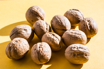 A small amount of unpeeled walnuts are on the table. Hard light