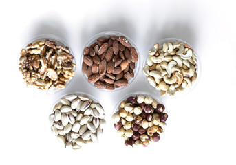 Obraz premium Healthy food. Nuts mix assortment on white grey table top view. Collection of different legumes for background image close up nuts, pistachios, almond, cashew nuts, peanut, walnut. image