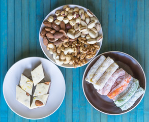 Oriental dessert halva with pistachio, almond, cashew nuts, peanut, walnut  on a  plate. Image. Healthy food. Nuts mix assortment. sweets, Turkish Delight. Isolated  background.. Eastern delicacy