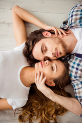 Vertical top above high angle view photo pair beautiful he him his macho she her lady just married honeymoon eyes closed overjoyed lying floor close faces in love apartments flat bright room indoors