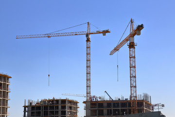 Large industrial construction crane against the blue summer sky