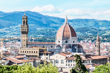 Fototapeta na wymiar Picturesque view of beautiful Florence and the Apennines. The dome of the Cathedral of Santa Maria della Grazia and the Palazzo Vecchio tower