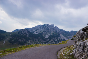 Fototapeta premium Empty asphalt road in the mountains and forest on the side. Background blur from movement speed.