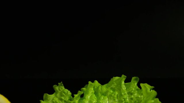 Commercial packshot of king prawns, lemon and fresh salad on the black background