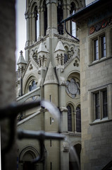 Fototapeta na wymiar Detalle de una iglesia en la ciudad suiza de Bern con un primer plano de las tipicas fuentes de la misma ciudad.