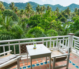 Table and chairs on the terrace for dining and enjoy the beautiful natural landscape of forest and mountains in the morning atmosphere at Phangan island Thailand