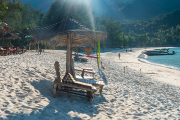Tropical background from Phangan  island in Thailand with beach chair on green meadow with blue sky and palm trees. Travel Vacation concept