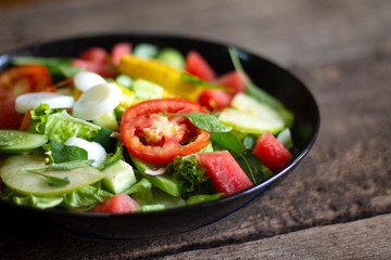Healthy and tasty food: salad of zucchini, tomatoes, lettuce with lime and spices close-up on a plate on the table. horizontal 