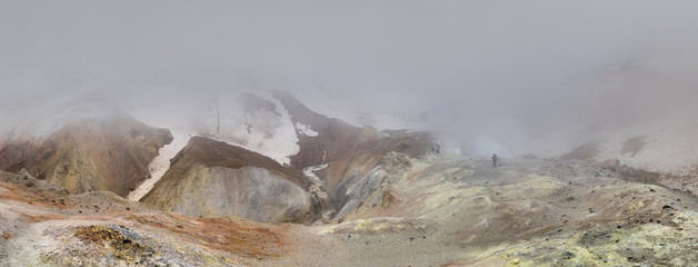 group of Mutnovsky volcanoes and tourists in the fog on the Kamchatka Peninsula