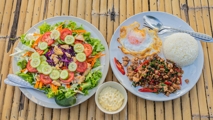 Thai fast food , Khao Pad Krapow (Fried rice with basil leaves) with Fried egg and Salad.