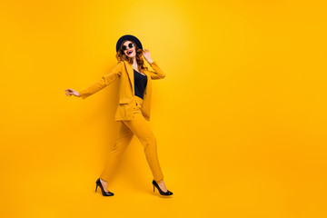 Fototapeta na wymiar Full length side profile body size photo beautiful amazing funky she her lady walking down street perfect look tourism traveler wear specs formal-wear costume suit isolated yellow bright background