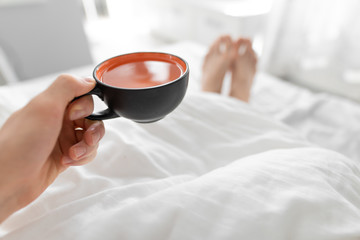 POV, man drinking morning tea in a bed