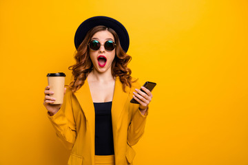 Close up photo beautiful funky she her lady open mouth amazed hands arms telephone vacation traveler hot beverage paper container reader wear specs formal-wear suit isolated yellow bright background