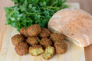 Falafel balls and pita on wood rustic background. Falafel is a traditional Middle Eastern food, commonly served in a pitta. 