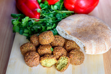 Falafel balls,sweet red pepper ,pita-arabian bread and green fresh parsley  on wood rustic background. Falafel is a traditional Middle Eastern food, commonly served in a pitta. 