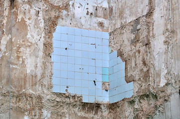 Blue tiles on a wall of a house being demolished.