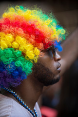 Spectator at gay pride parade wearing a rainbow Afro wig