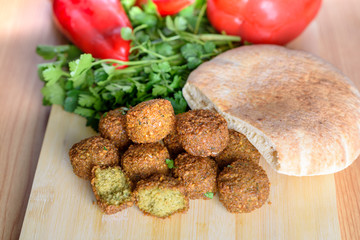 Falafel balls,sweet red pepper ,pita-arabian bread and green fresh parsley  on wood rustic background. Falafel is a traditional Middle Eastern food, commonly served in a pitta. 