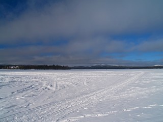 Fototapeta na wymiar Zugefrorener See mit Eis und Schnee Horizont Panorama