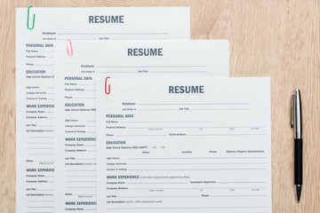 top view of print resume templates and pen on wooden surface