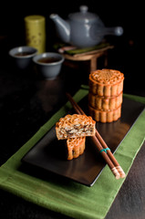Mid Autumn Festival Mooncake served on a black plate with chinese tea
