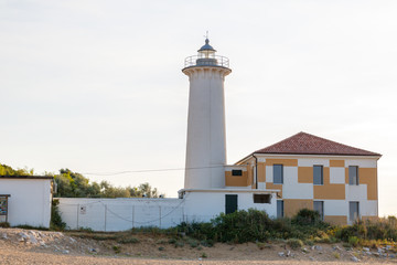 Fototapeta na wymiar lighthouse on the seashore in the rays of dawn