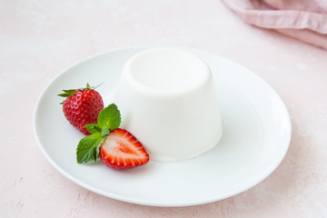 Panna cotta, traditional italian dessert, served with fresh strawberry and mint