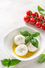 Mozzarella cheese with olive oil and basil in bowl