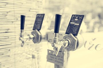 Closeup of metallic tap for pouring organic juices in bulk shopping store.