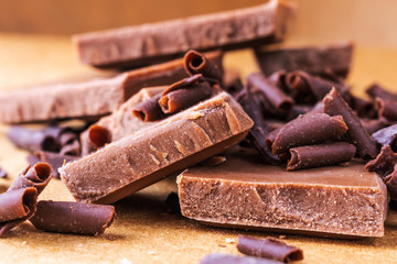 Milk chocolate and chocolate chips close up. Photo in warm colors. Sweetness. World chocolate day....