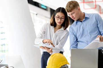 Obraz premium Architect designer engineer team colleagues working with blueprint and tablet in office.