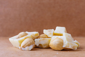 Slices of white chocolate with hazelnuts close-up. Photo in warm colors. Sweetness. World chocolate day