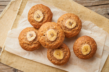 Banana muffin, top view. Cupcakes on old linen napkin, rustic wooden table, breakfast with cake