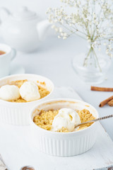 Apple crumble with streusel on a light gray table. Vertical. Morning breakfast.