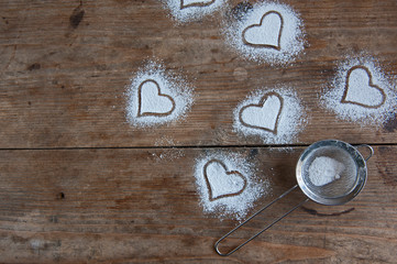 Heart powdered sugar on the rustic background
