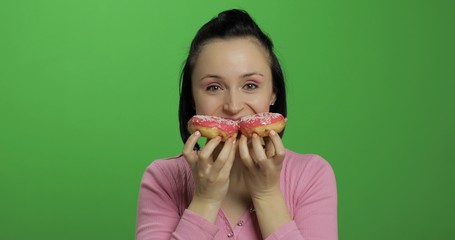 Happy beautiful young girl posing and having fun with donuts. Chroma key