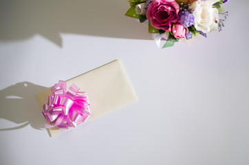 Fototapeta na wymiar gift envelope and flowers on a white background