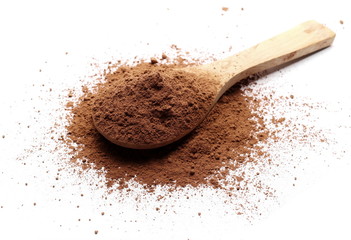 Cocoa powder pile with wooden spoon isolated on white background