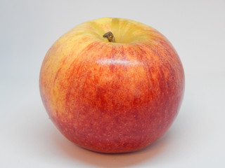 One isolated ripe yellow-red sweet and juicy apple closeup