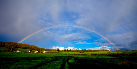 A rainbow panorama over farmland near Minehead, Somerset, England, UK.