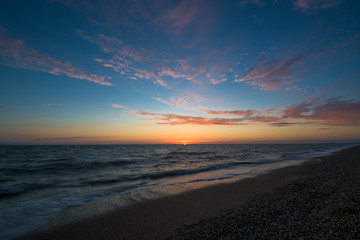 Obraz premium gorgeous sunset on the sea coast. photo on long exposure, waves at sea at sunset. pink sunset