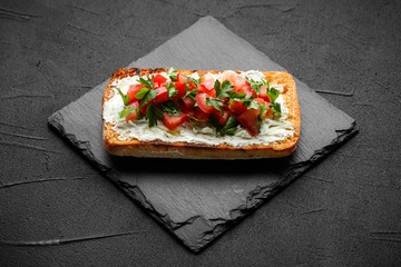 wholegraine ciabatta sandwich with sliced tomatoes, goat cheese, parsley. top view