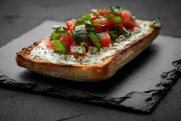 wholegraine ciabatta sandwich with sliced tomatoes, goat cheese, parsley. top view