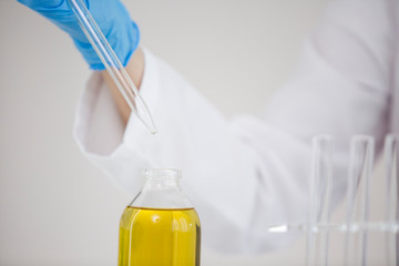 Close up of scientist working with pharmaceutical cbd oil in a laboratory with glass dropper and a...