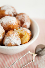 Homemade deep-fried cottage cheese donuts for Breakfast on a light wooden background close-up. Fresh pastries for the morning. Selective focus