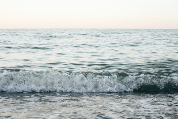 Beautiful sea waves foam close up from beach. Blue waves in ocean in evening time. Tranquil calm moment. Summer vacation. Copy space