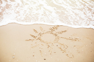 Sun sign on beach. Summer text, sun symbol on sandy beach with footprints and sea waves foam. Hello summer concept. Vacation, relax and travel. Copy space