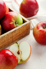 Harvest fresh ripe red apples in a wooden box on a white background top view.Organic vegetarian produce.Vertical orientation